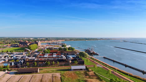 scenic view of lelystad, the netherlands and lake markemeer. approaching the wharf, museum batavialand and ships at the berth.