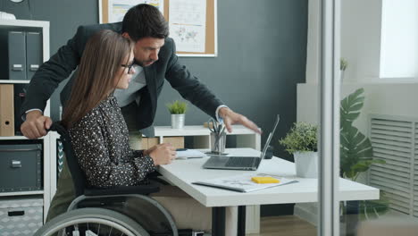 Business Colleague Helping Disabled Colleague