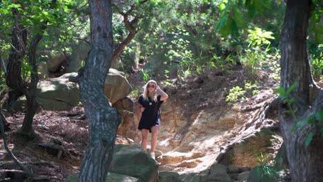 chica activa caminando por un camino rocoso a la sombra de los árboles que bloquean la luz del sol, estática