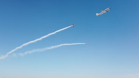 el biplano antiguo hace una acrobacia de bucle con rastros de humo.