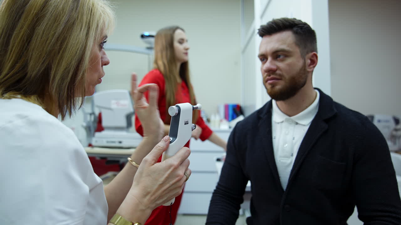 Doctor checking eyes with device. Female doctor examining eye with medical equipment
