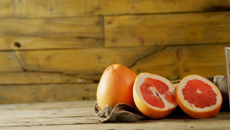 Grapefruit-Mit-Saftpresse-Auf-Holztisch-4k