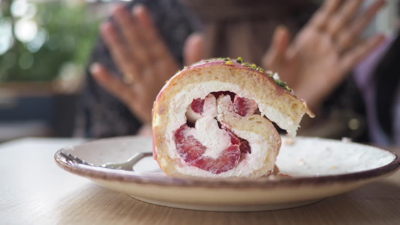 A close-up of a strawberry cake roll on a plate
