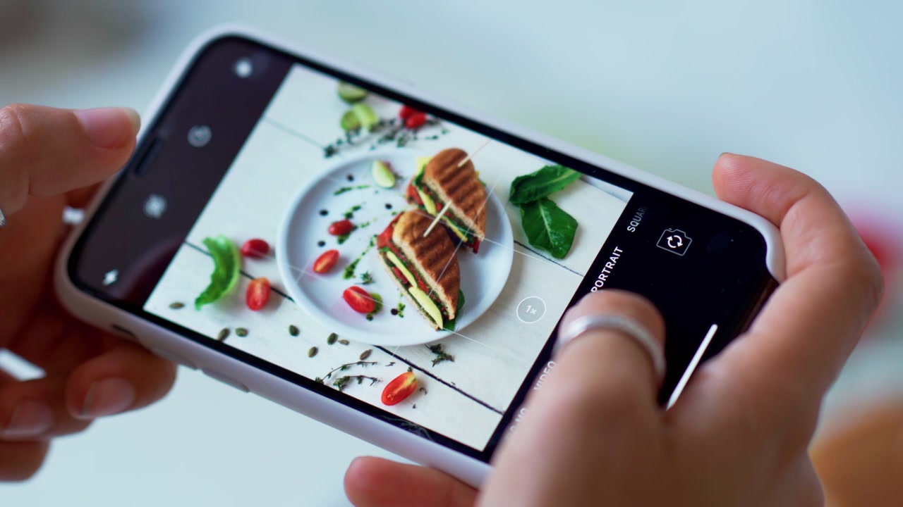 Person Taking a Photo of a Gourmet Panini Sandwich with a Smartphone