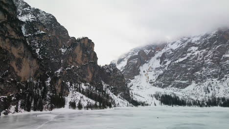 frozen braies lake against cloudy sky in trentino, italy - aerial drone shot