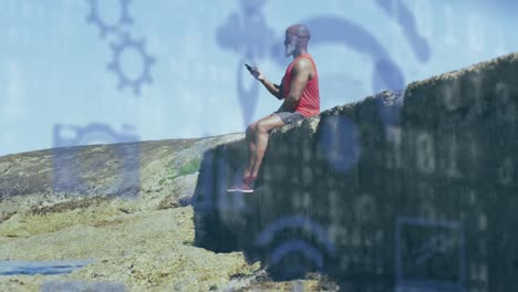 Animation-of-media-icons-over-senior-african-american-man-using-smartphone-at-beach