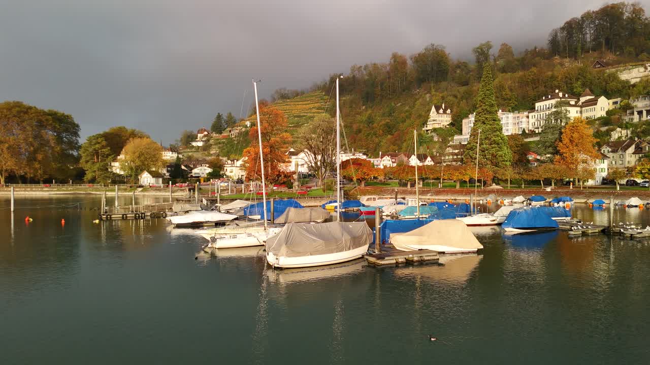 Autumn Switzerland small Swiss village, moored catamaran, multicolor foliage forest