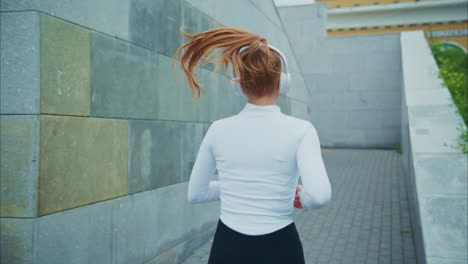 redhead woman running with headphones
