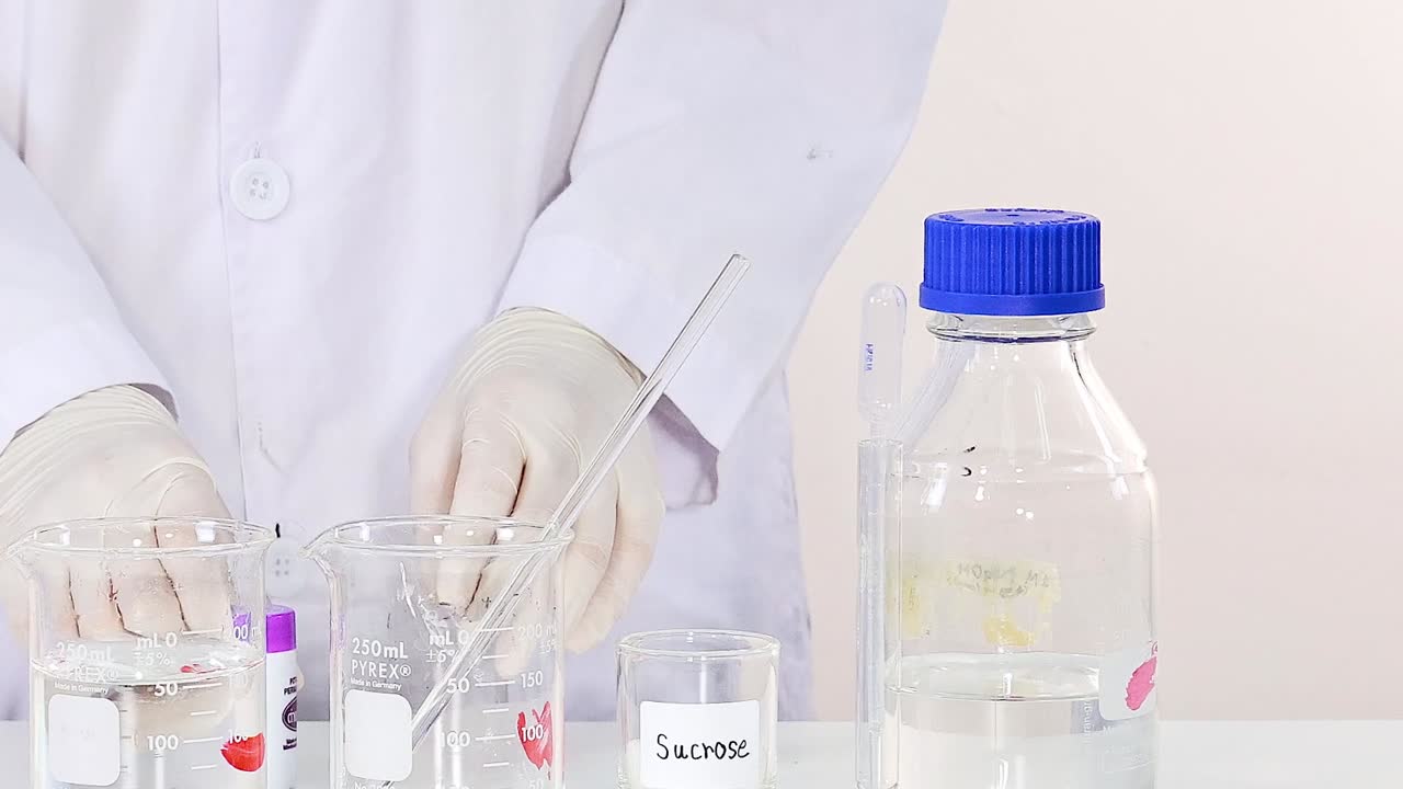 A scientist mixes solutions in a lab, focusing on precision and technique.