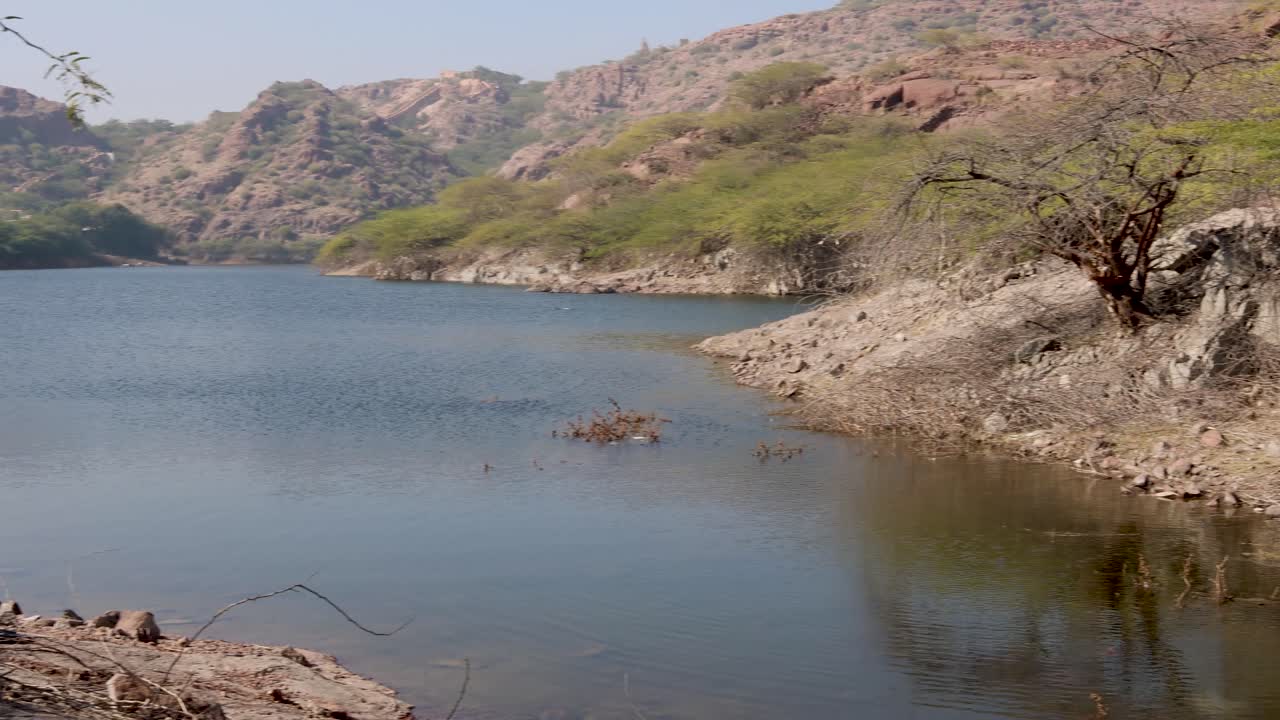 pristine lake calm water with mountain background at day from different angle video is taken at kaylana lake jodhpur rajasthan india