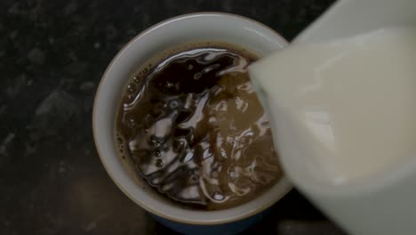 Vertiendo-Leche-En-Una-Taza-De-Café-Instantáneo-Negro-En-Cámara-Lenta