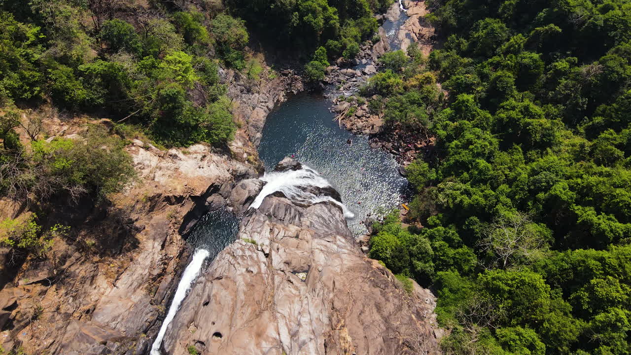 vista aérea de las cataratas de dudhsagar rodeadas de vegetación exuberante en goa, india - toma de avión no tripulado