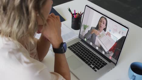 Caucasian-businesswoman-using-laptop-for-video-call-with-biracial-business-colleague