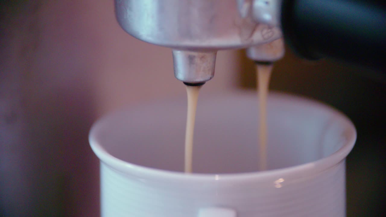 Coffeecup under espresso maker in slow motion