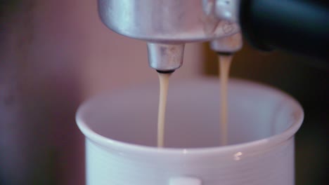 taza de café bajo la máquina de espresso en cámara lenta