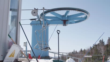 empty ski chairlift bullwheel turns around on top mountain terminal