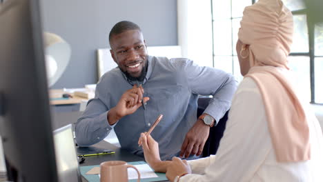 smiling businessman discussing work with colleague in modern office setting