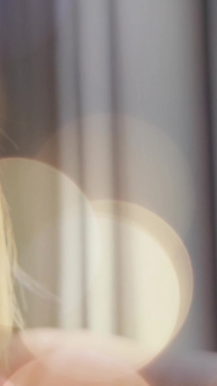 Smiling person near window with bokeh light animation in background