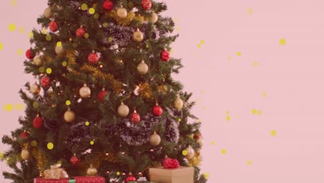 Animation-of-yellow-spots-of-light-floating-over-a-decorated-christmas-tree-and-gifts