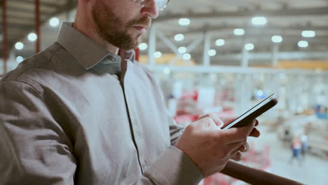 close-up of engineer texting on smartphone in industrial factory