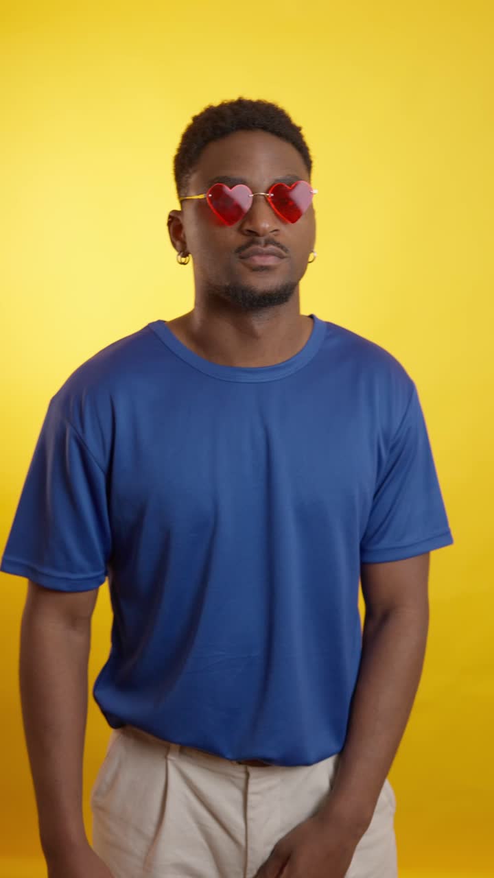 Man with heart glasses on yellow background