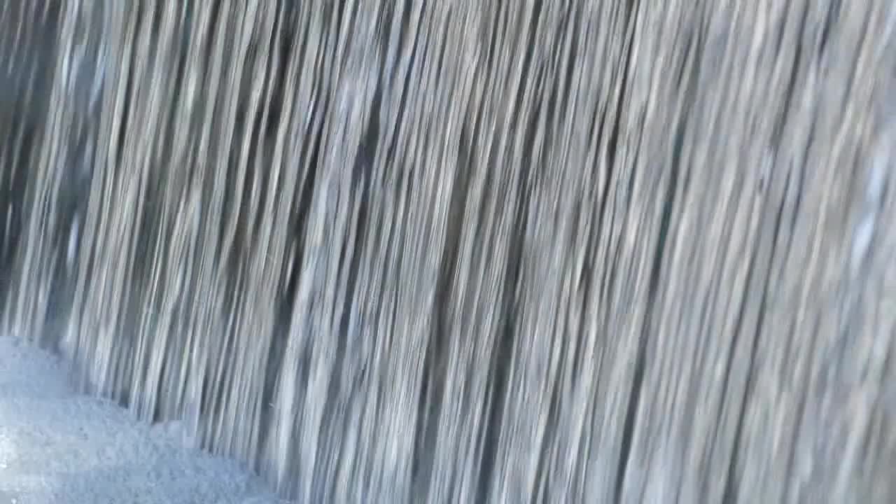 el agua fluye rápidamente sobre el borde creando una pared de agua