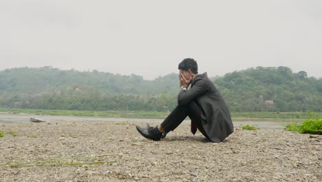 depressed businessman by the river