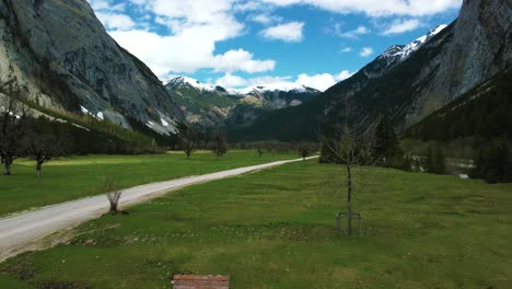 drone flight at beautiful ahornboden mountain valley along the rissach river with fresh blue water in the bavarian austrian alps on a cloudy and sunny day along trees, rocks, forest and hills