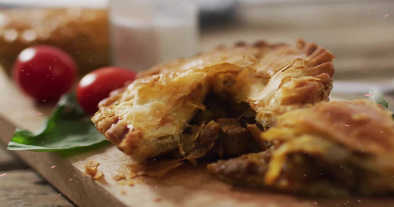 Un coltello taglia una torta salata dorata, facendo fuoriuscire il ripieno su un tagliere di legno per mostrare la consistenza.