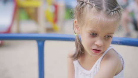 little girl spinning merry go round carousel amusement park playground summer day