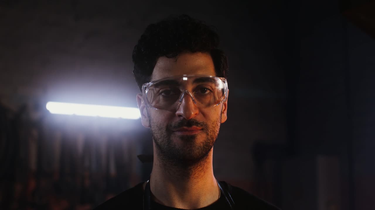 primer plano de un trabajador concentrado en un taller oscuro