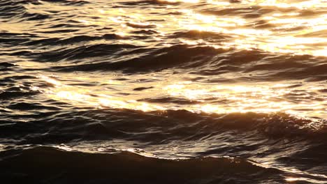 vagues de l'océan au ralenti scintillant au coucher du soleil