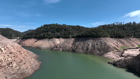 Aerial-view-of-Vilanova-de-Sau-reservoir-dry-banks,-forward,-Catalonia,-Spain