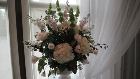 Flower-bouquet-panning-out-to-reveal-a-beautiful-wedding-altar-made-from-white-drapery