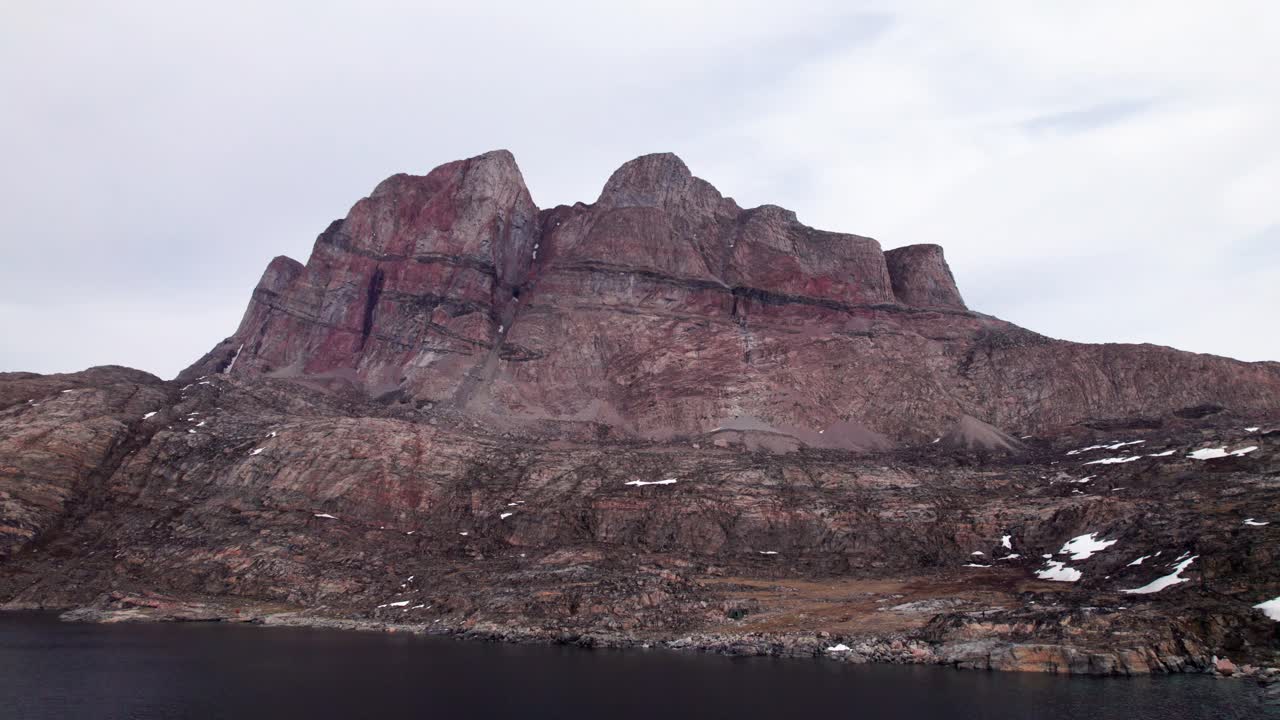 Stunning aerial footage flying over the Uummannaq Fjord. Majestic, red mountain