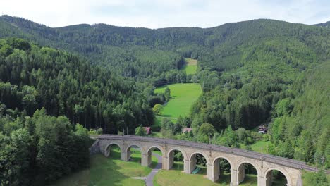 Semmering-Railway-World-Heritage-Unesco-Site-in-Austria-filmed-from-above-with-a-drone-in-4K-surrounded-by-forest