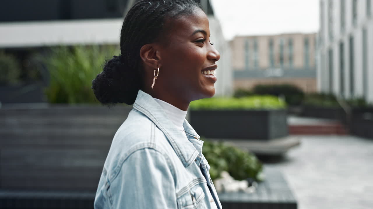 A smiling young woman in a denim jacket