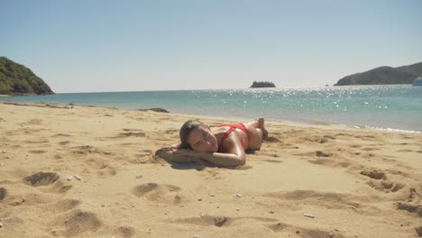 mujer turista relajándose y tomando el sol en la playa de arena en la isla de langford, whitsundays, queensland en verano