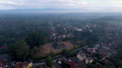 Mendut-temple-surrounded-by-small-township-in-Central-Java,-Indonesia,-aerial-view