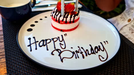 revealing of happy birthday written on plate and cutting of cake by a woman in a hotel of bali, indonesia.