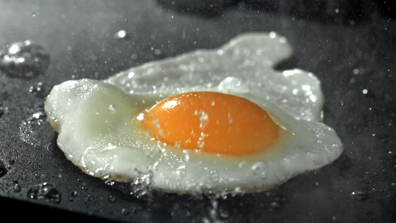Close-up of a Fried Egg Sizzling on a Hot Pan
