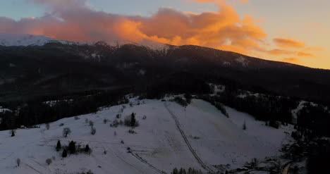 Vista-Aérea-De-Montañas-Y-Bosques-Cubiertos-De-Nieve-Al-Atardecer-En-Invierno-6