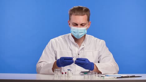 el trabajo del médico masculino en el laboratorio, explorando una vacuna y haciendo entradas de registro. coronavirus, covid-19, 2019-ncov medicamentos concepto de investigación. pantalla azul clave de croma. cerrar. cámara lenta