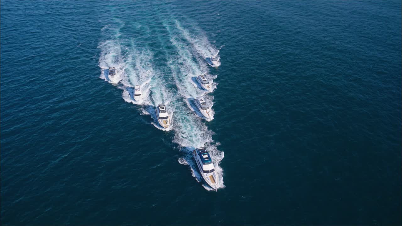 고급 요트들이 조화롭게 항해하는 모습의 영화 같은 항공 촬영 장면