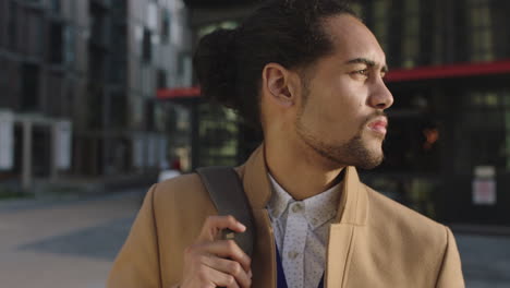 portrait-of-young-businessman-commuter-leaving-work-looking-serious-pensive-wearing-backpack-waiting-in-city