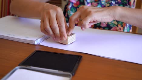 woman puts a stamp on empty notepad page