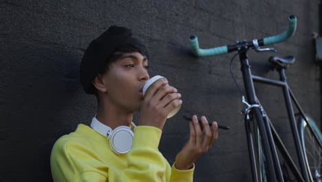 transgender adult drinking coffee in the street