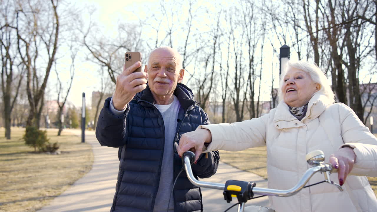 Pareja mayor tomándose un selfi con el smartphone mientras camina