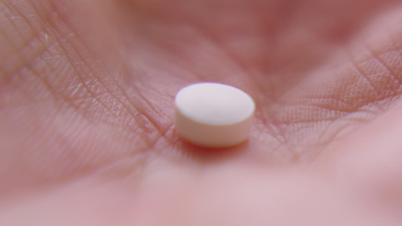 Macro primo piano di una piccola pillola di integratore alimentare di Vitamina D. Ideale per spiegazioni sanitarie, pubblicità farmaceutiche o presentazioni di ricerca medica