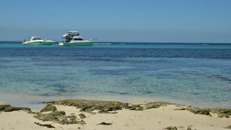 two luxury yachts float in the crystal clear waters